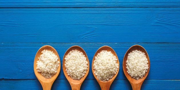 Rice on wooden spoon with blue color wood.