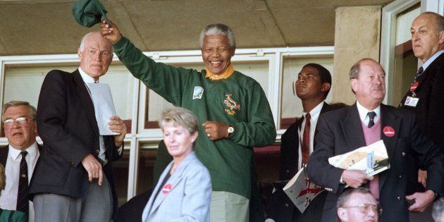 South African president Nelson Mandela wearing a Springbok jersey and cap waves upon arriving at Ellis Park in Johannesburg for the Rugby World Cup final on June 24 1995.