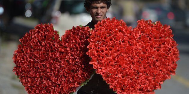 A Pakistani vendor carries heart-shaped bouquets for sale ahead of Valentine's Day along a street in Islamabad, Pakistan, on February 13, 2017.