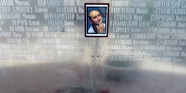 Flowers lie under a picture of 41-year-old anti-Kremlin reporter Arkady Babchenko on the memorial wall of Moscow's journalists house in Moscow on May 30 2018. The prominent Russian war correspondent and former soldier was shot dead on May 29 in an apparent contract-style killing in the stairwell of his building in Kyiv.