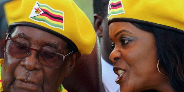 President Robert Mugabe listens to his wife Grace Mugabe at a rally of his ruling ZANU-PF party in Harare, Zimbabwe, November 8, 2017.REUTERS/Philimon Bulawayo TPX IMAGES OF THE DAY