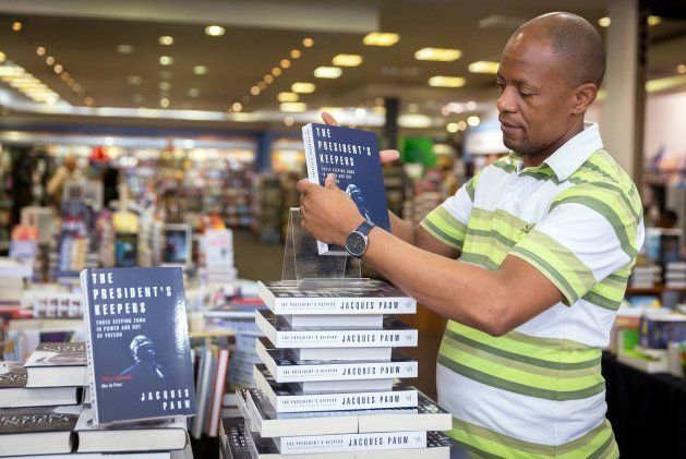 A staff member of the Exclusive Books bookshop at the Gateway Mall in Durban sets up a shelf with the new book 'The President's Keepers' written by investigative journalist and author Jacques Pauw on October 29, 2017 in Durban, South Africa.