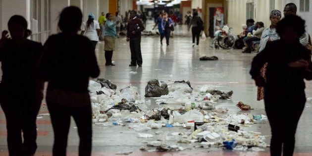 Patients walk through waste and garbage bags at the Charlotte Maxeke Hospital in Johannesburg, during a protest by the employees on May 31 2018.