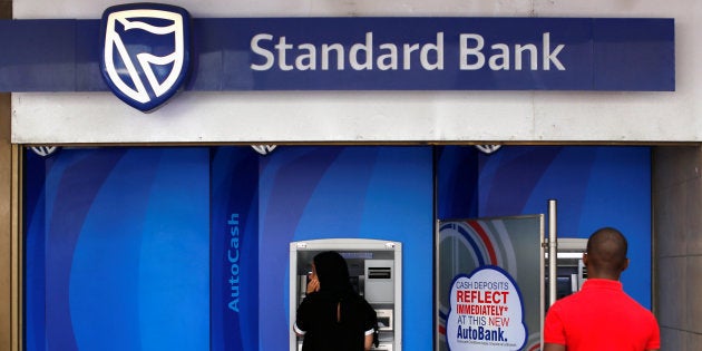 Customers queue to draw money from an ATM outside a branch of South Africa's Standard Bank in Cape Town, March 15, 2016. REUTERS/Mike Hutchings