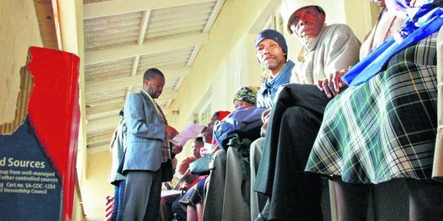 Elderly people wait in a queue to get their social grant payments processed at the South African Social Security Agency.