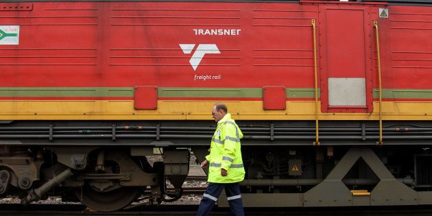 Jacobus van der Merwe, a train driver, passes a locomotive operated by Transnet at the company's rail depot in Ermelo, March 10, 2014.