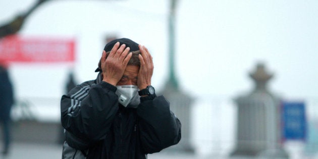 A man wearing a mask is seen in smog during a polluted day in Harbin, Heilongjiang province, China, December 19, 2016. REUTERS/Stringer ATTENTION EDITORS - THIS PICTURE WAS PROVIDED BY A THIRD PARTY. EDITORIAL USE ONLY. CHINA OUT.