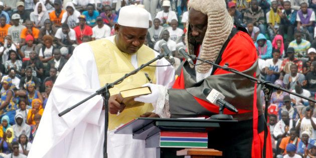 Gambia's new President Adama Barrow holds the Koran during the swearing-in ceremony at the Independence Stadium, in Bakau, Gambia, on February 18, 2017.