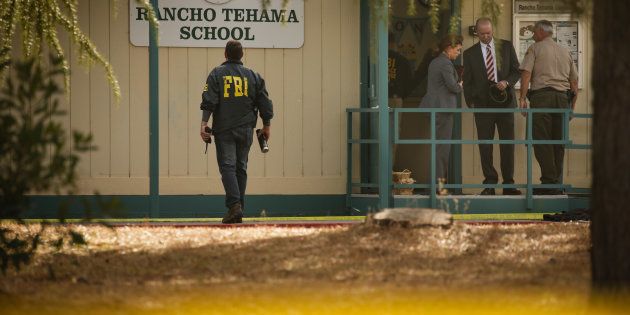 FBI agents are seen behind yellow crime scene tape outside Rancho Tehama Elementary School after a shooting in the morning on November 14, 2017, in Rancho Tehama, California