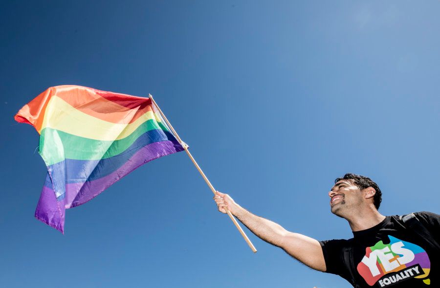 Sydney, Australia -- November 15: A man proudly waves the LGBTQ Pride Flag.