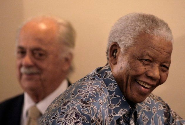 Former South African president Nelson Mandela (R) walks past George Bizos, his lifelong friend as he leaves the media briefing after his acceptance of the historical collections from the National Archives at the Mandela foundation in Houghton.