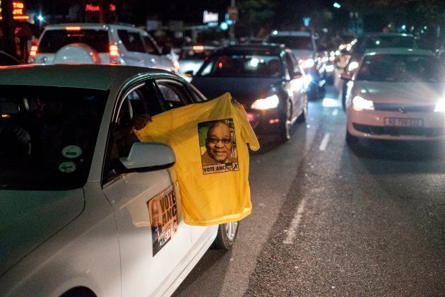 A motorist holds a shirt out of a car window bearing the portrait of former South African President Jacob Zuma as Zuma supporters drive in a motorcade through a popular area of Durban in a show of support on the eve of his court hearing on corruption charges on June 7, 2018. (Photo by MARCO LONGARI / AFP) (Photo credit should read MARCO LONGARI/AFP/Getty Images)