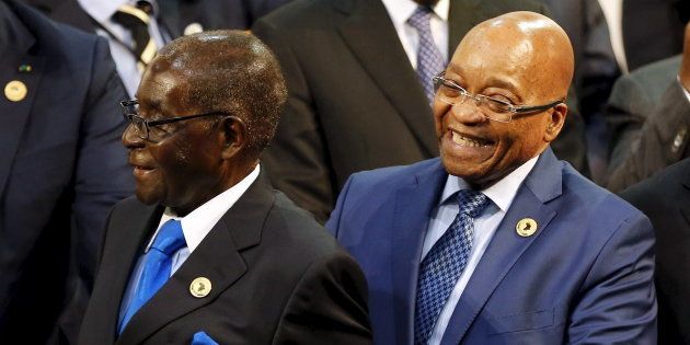 Zimbabwe President Robert Mugabe (L) reacts next to South Africa's President Jacob Zuma during the opening of the 25th African Union summit in Johannesburg, June 14, 2015.