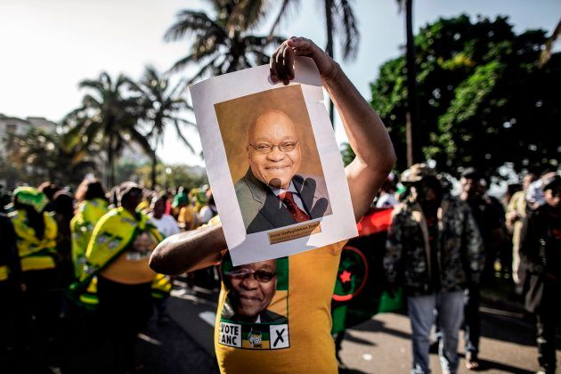 A supporter wearing ANC colours holds a portrait of Jacob Zumaat a rally in support of Zuma on June 8 2018 outside the High Court in Durban.