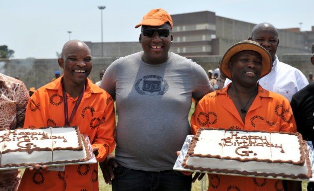Controversial South African businessman, Gayton Mckenzie poses with his birthday cakes held by prison inmates at Johannesburg Central Prison on March 10 2011 in Johannesburg.