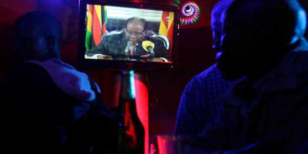 People watch as Zimbabwean President Robert Mugabe addresses the nation on television, at a bar in Harare, Zimbabwe, November 19, 2017. REUTERS/Philimon Bulawayo