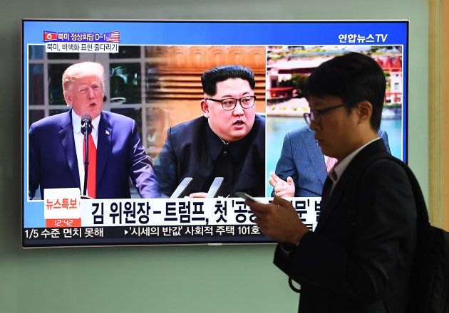 A man walks past a television news screen showing US President Donald Trump (L) and North Korean leader Kim Jong Un (C), at a train station in Seoul on June 11, 2018. - Kim Jong Un and Donald Trump will meet on June 12 for an unprecedented summit in an attempt to address the last festering legacy of the Cold War, with the US President calling it a 'one time shot' at peace. (Photo by Jung Yeon-je / AFP) (Photo credit should read JUNG YEON-JE/AFP/Getty Images)