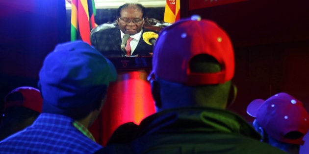 People watch as Zimbabwean President Robert Mugabe addresses the nation on television, at a bar in Harare, Zimbabwe, November 19, 2017.