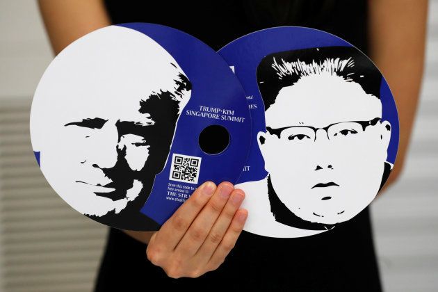 A worker of a media center for the summit between the U.S and North Korea shows fans featuring the images of U.S. President Donald Trump (L) and North Korean leader Kim Jong Un, which provided for journalists in a media kit at the media center in Singapore, June 10, 2018. REUTERS/Kim Kyung-Hoon