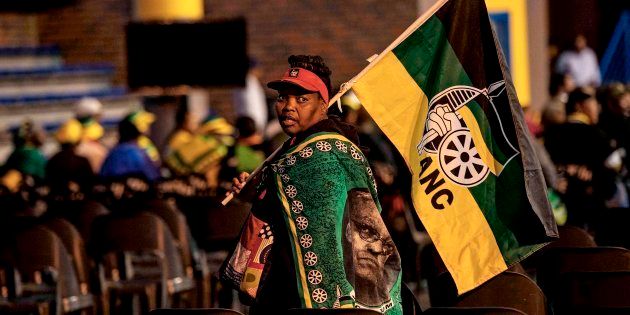 ANC supporter walks with the party's flag at the Orlando Communal Hall on November 13, 2017 in Johannesburg, South Africa.