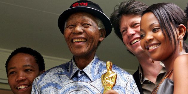 Former South African President Nelson Mandela (2nd L) poses with actor Presley Chweneyagae (L), actress Terry Pheto (R) and the director Gavin Hood of the Oscar-winning film