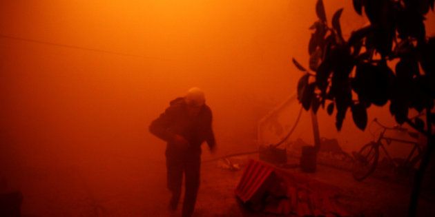 FILE PHOTO: A civil defence member runs at a site hit by an airstrike in the rebel held besieged Douma neighbourhood of Damascus, Syria November 23, 2016.Syrian cameraman Khaled Khatib whose documentary about the