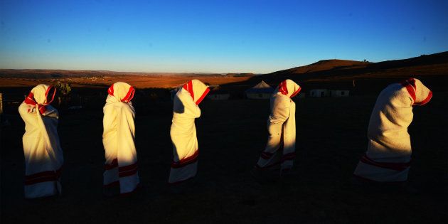 Initiates are smeared with white clay on their face and are covered in red and white blankets on June 20, 2014 in Ngunjana Village, South Africa.