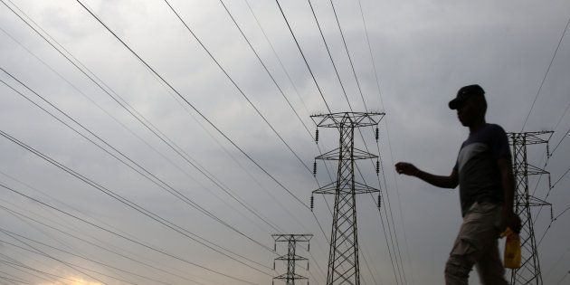 A man walks past electricity pylons in Soweto, South Africa, March 5, 2018. REUTERS/Siphiwe Sibeko