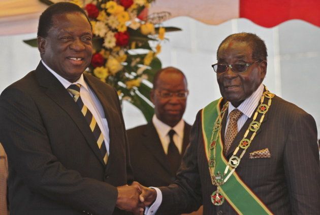 President Robert Mugabe (R) greets Vice President Emmerson Mnangagwa as he arrives for Zimbabwe's Heroes Day commemorations in Harare, August 10, 2015.