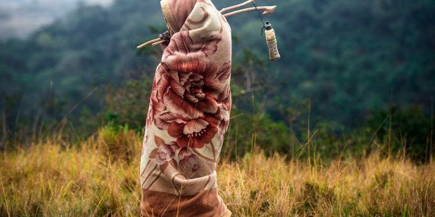 Traditional Xhosa initiate Khanyisile Mapope (R), 18 years old, walks through the bush during a traditional initiation process, in a rural hut on July 13, 2017 in the Coffee Bay area in Umtata, South Africa.