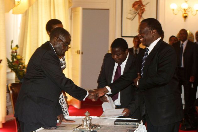 Zimbabwe's former president Robert Mugabe congratulates Emmerson Mnangagwa (R) after he was sworn in as Zimbabwe's vice president at the State House in Harare, December 12, 2014.