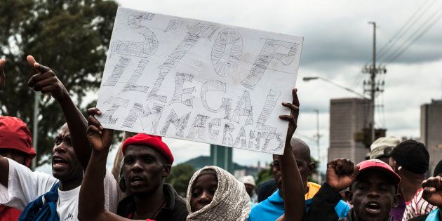 Protesters sing and chant during protest over immigrants in Pretoria on February 24. Police fired rubber bullets and stun grenades to control the situation.