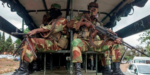 Masked Zimbabwean soldiers patrol the streets during a rally to demand the resignation of its president on November 18 in Harare.