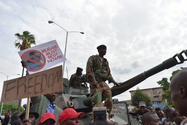 Zimbabwean Defence Force soldiers stand on a tank as they move forward through a crowd of people during a march in the streets of Harare, on November 18, 2017 to demand to the 93 year-old Zimbabwe's president to step down.