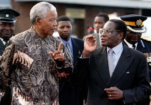 President's Nelson Mandela of South Africa (L) and Robert Mugabe of Zimbabwe talk together May 21, 1997 as he was leaving the country after a three day state visit. Mandela opened a World Economic Forum on the southern African region to improve investment and trade within the region. REUTERS/Howard Burditt ZIMBABWE MANDELA