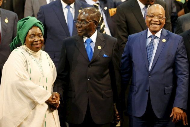 Chairperson of the African Union (AU) Commission Nkosazana Dlamini-Zuma (L) smiles as she is greeted by Zimbabwe's President Robert Mugabe next to South Africa's president Jacob Zuma ahead of the 25th African Union summit in Johannesburg June 14, 2015. REUTERS/Siphiwe Sibeko