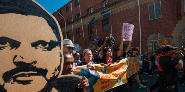 Thousands of people march through the city centre to the South African Parliament, waving South African flags and banners, calling for the South African president to step down on April 7, 2017, in Cape Town.