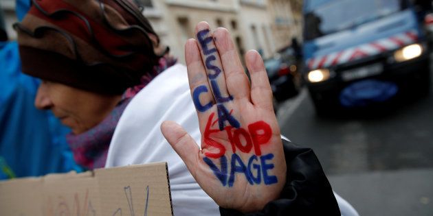 A woman displays her hand with the message