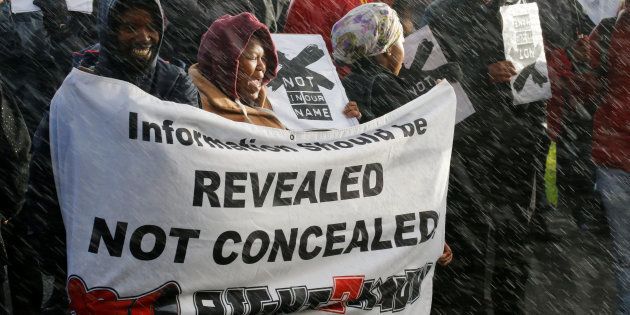 Demonstrators protest in the rain against the decision by public broadcaster the South African Broadcasting Corporation (SABC) that it would not broadcast scenes of violent protest, in Cape Town, South Africa, July 1, 2016.