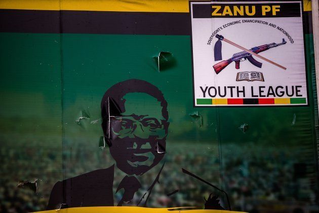 This photo taken on November 19, 2017 shows a vandalised billboard of Zimbabwe's president Robert Mugabe in front of the ZANU-PF (Zimbabwe African National Union - Patriotic Front) political party headquarters in Harare.