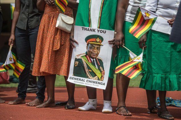 Supporters hold posters of Zimbabwe Army Chief of Staff General Constantino Chiwenga during newly sworn-in President Inauguration ceremony at the National Sport Stadium in Harare, on November 24, 2017.