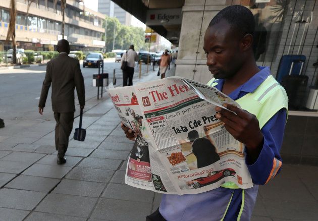 A Zimbabwean vendor reads a newspaper after President Robert Mugabe resigned in Harare, Zimbabwe, November 22, 2017.