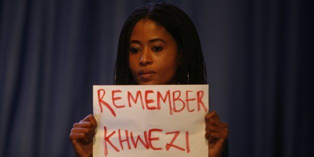 A young woman holds a poster written Remember Khwezi during President Jacob Zumas speech at the IEC briefing after the 2016 local government elections on August 06, 2016 in Pretoria, South Africa. Four women staged an anti-rape silent protest directed at Zuma while he delivered his speech during the announcement of the final election results.