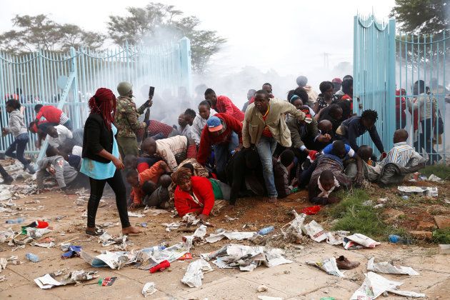 People fall as police fire tear gas to try control a crowd trying to force their way into a stadium to attend the inauguration of President Uhuru Kenyatta at Kasarani Stadium in Nairobi, Kenya November 28, 2017.