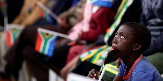 A boy holds a flag as South Africa's President Jacob Zuma addresses the National Youth Day commemoration, under the theme