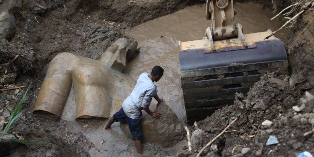 An Egyptian worker prepares to lift parts of a statue at the site of a new archeological discovery at Souq Al-Khamis district in Al-Matareya area, Cairo, Egypt on March 9, 2017. According to the Ministry of Antiquities, two 19th dynasty royal statues were found in parts in the vicinity of King Ramses II temple in ancient Heliopolis (Oun) Sun Temples by a German-Egyptian archeological mission.