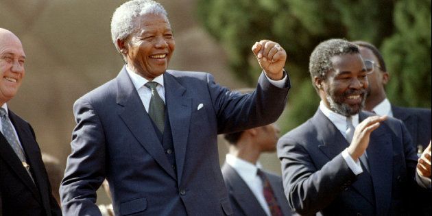 Nelson Mandela dances in front of the crowd at the Union Buildings after he was inaugurated as South Africa's first democratic president in May 1994. On the left is second Deputy President F.W. de Klerk and, on the right, first Deputy President Thabo Mbeki. Renewed allegations of a plot to kill Mandela at the inauguration are emerging in a court case.