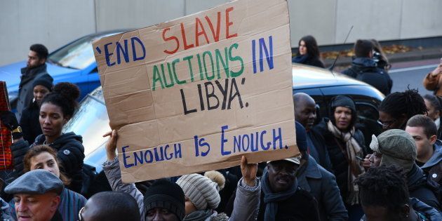 A protester holds a sign-board during an anti-slavery demonstration outside the Embassy of Libya in London, United Kingdom on November 26, 2017 to protest the human rights violations in Libya. (Photo by Alberto Pezzali/NurPhoto via Getty Images)