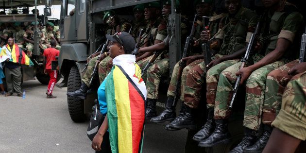 A local poses in front of a military truck after the swearing in of Zimbabwe's President Emmerson Mnangagwa in Harare, Zimbabwe, on November 24, 2017.