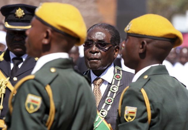 President Robert Mugabe walks past soldiers as he arrives for Zimbabwe's Heroes Day commemorations in Harare, August 10, 2015.